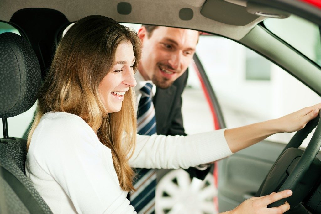 woman looking at the car with salesman