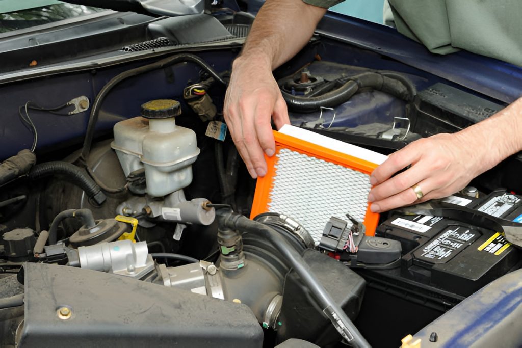 close-up of a man changing a car air filter