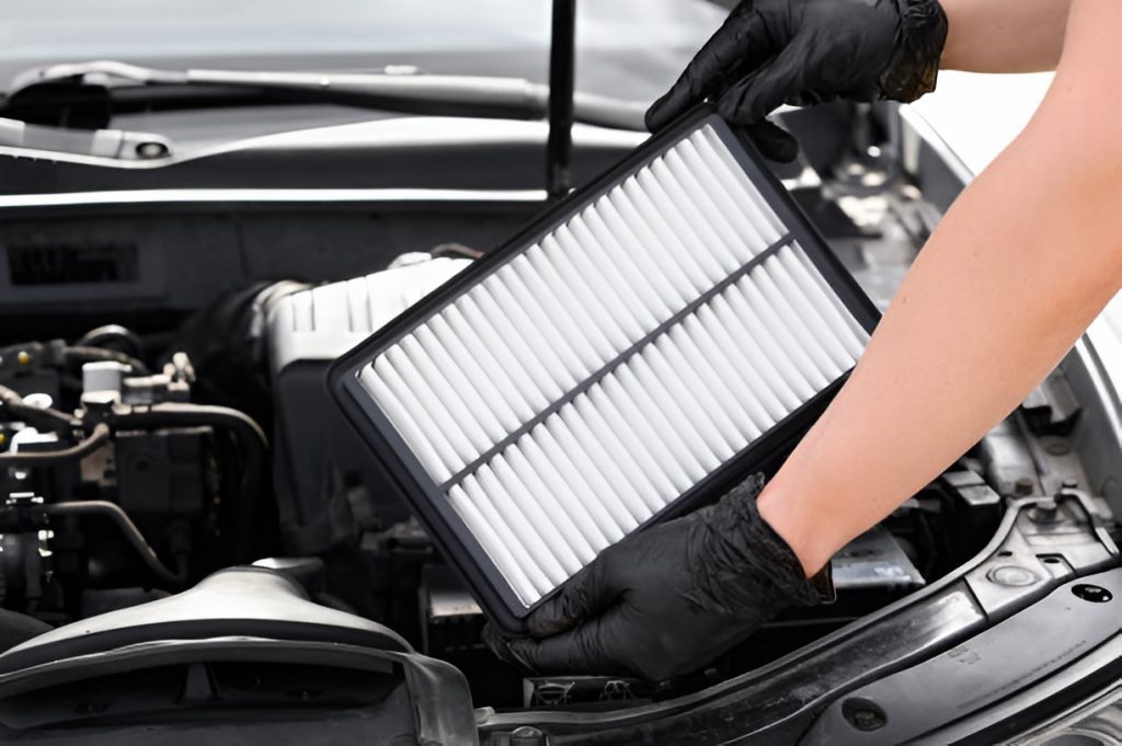 close-up of a man replacing a car air filter